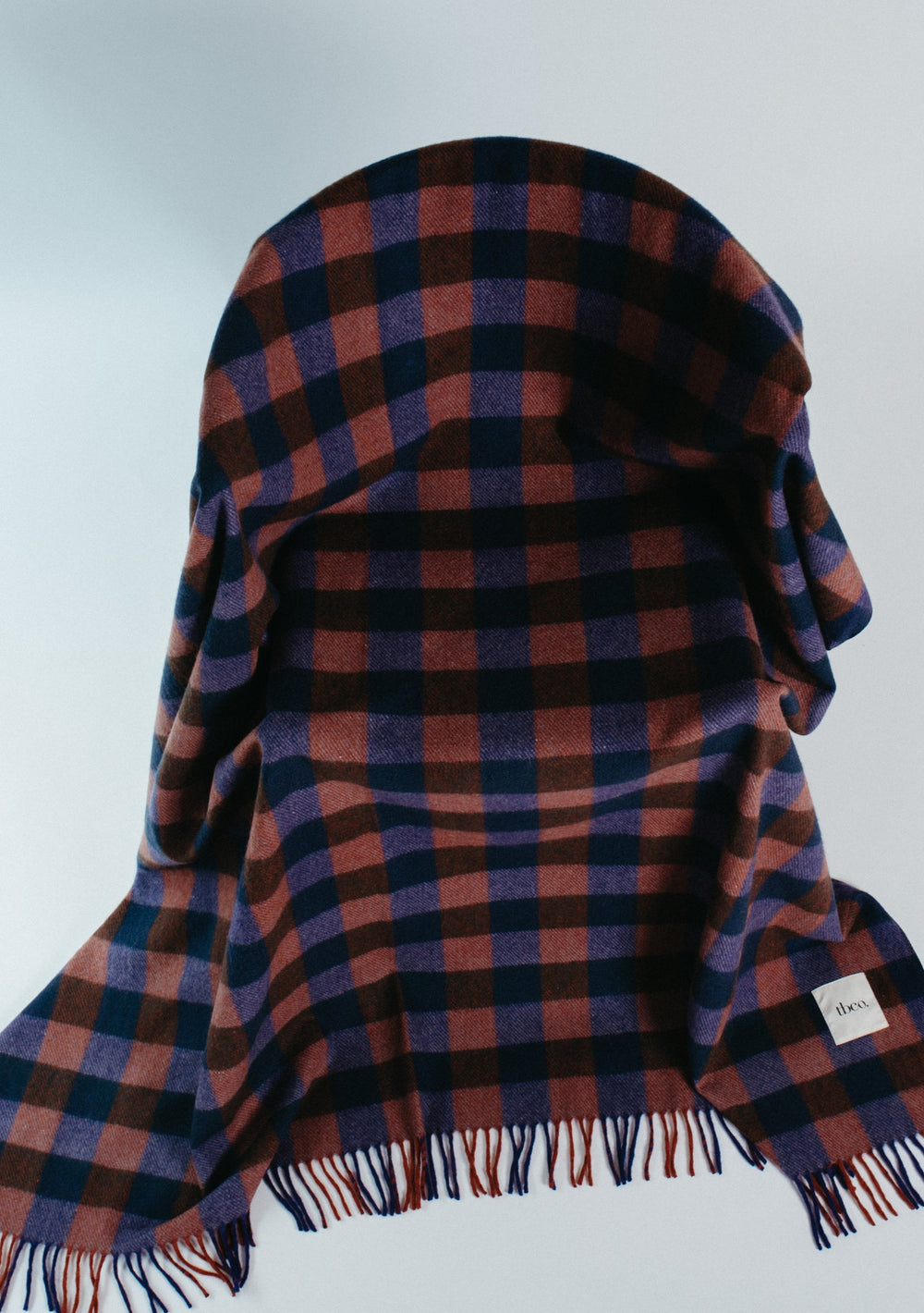 Recycled Wool Blanket in Midnight Gingham by TBCo with navy and brown checks and fringed edges for cosy comfort