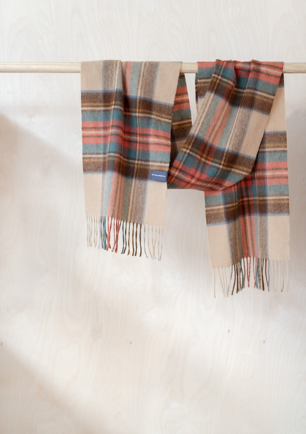 TBCo Mens Cashmere Scarf in Stewart Dress Antique Tartan displayed draped over wooden rail showing plaid pattern and fringed ends