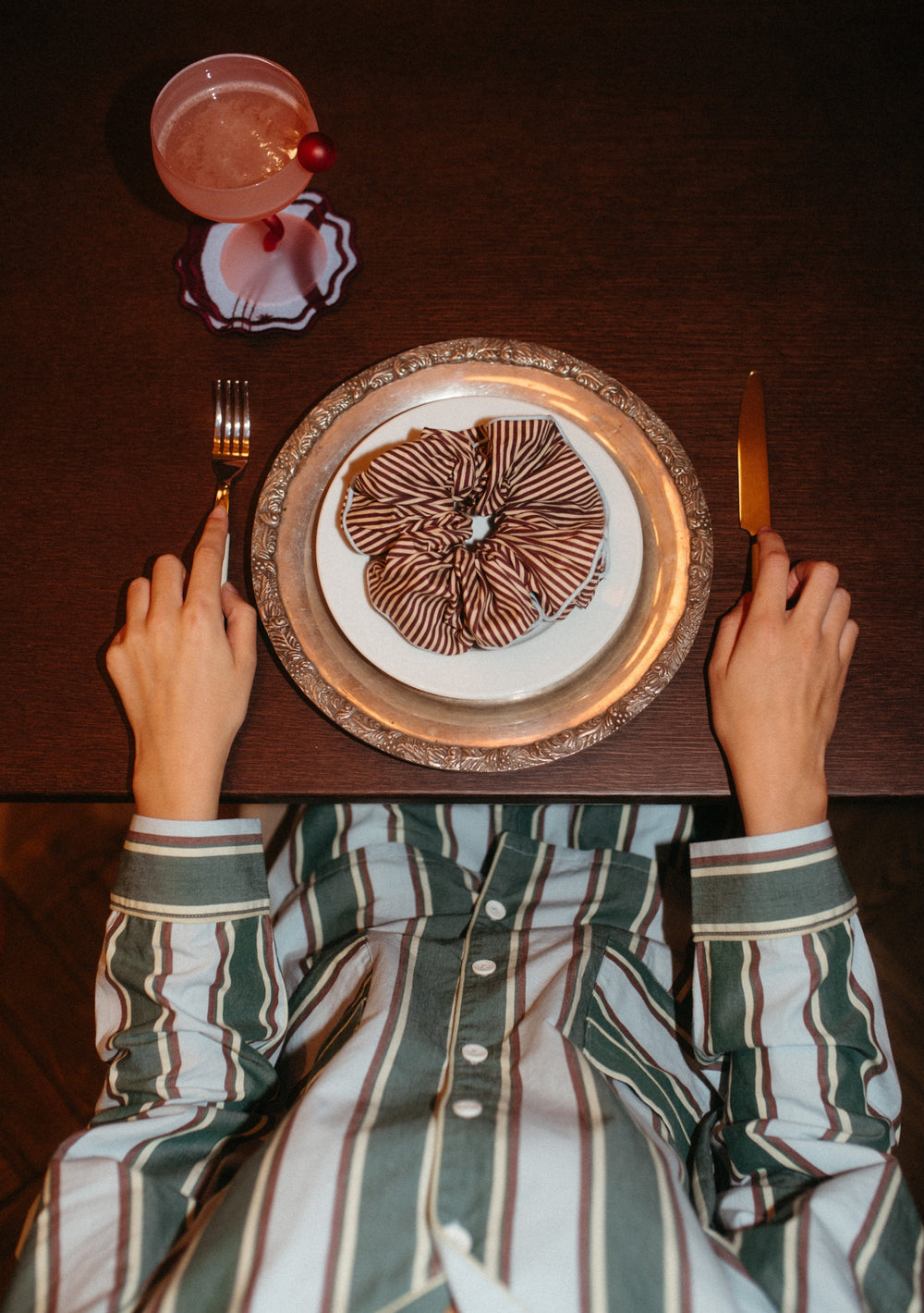 Cotton Oversized Scrunchie in Camel Stripe by TBCo displayed on plate with fork and knife on wooden table.