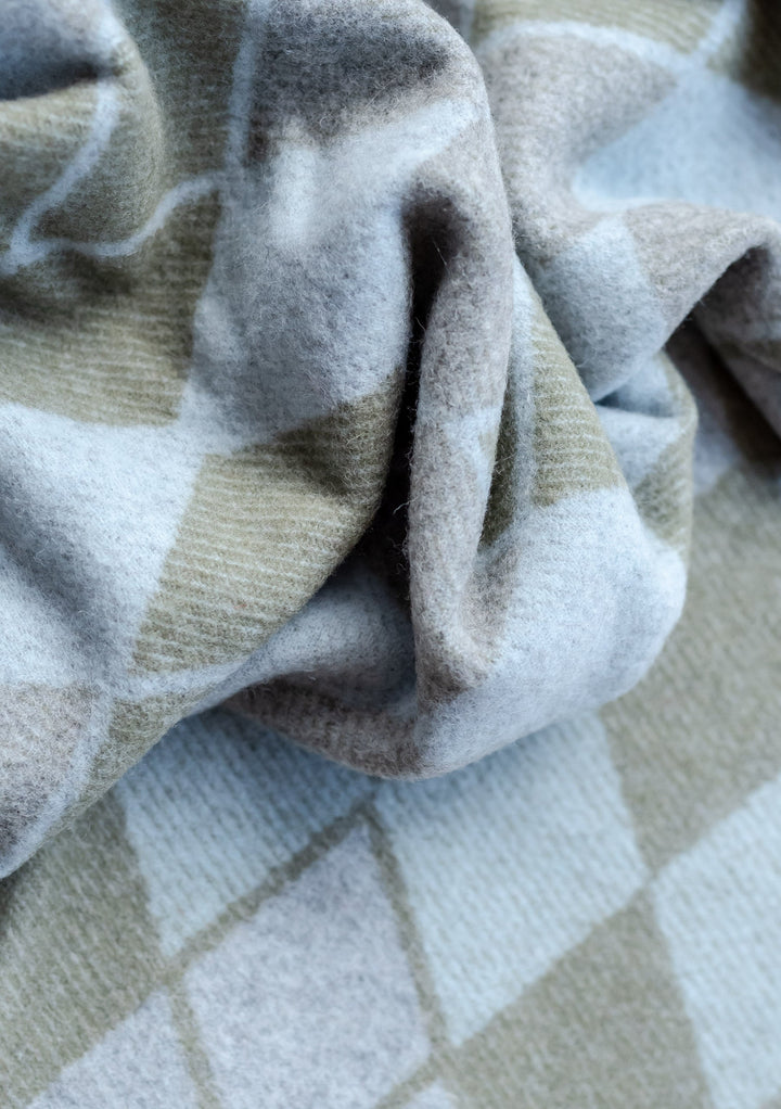 Close-up texture of TBCo x Amy Bell Dunnottar Scarf in soft grey lambswool showing detailed weave pattern and fabric draping