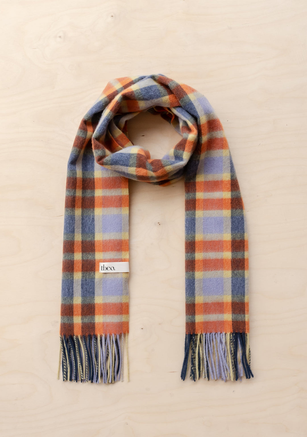 TBCo Lambswool Oversized Scarf in Lilac Multi Check laid flat showing lilac, indigo, orange plaid pattern with fringed ends