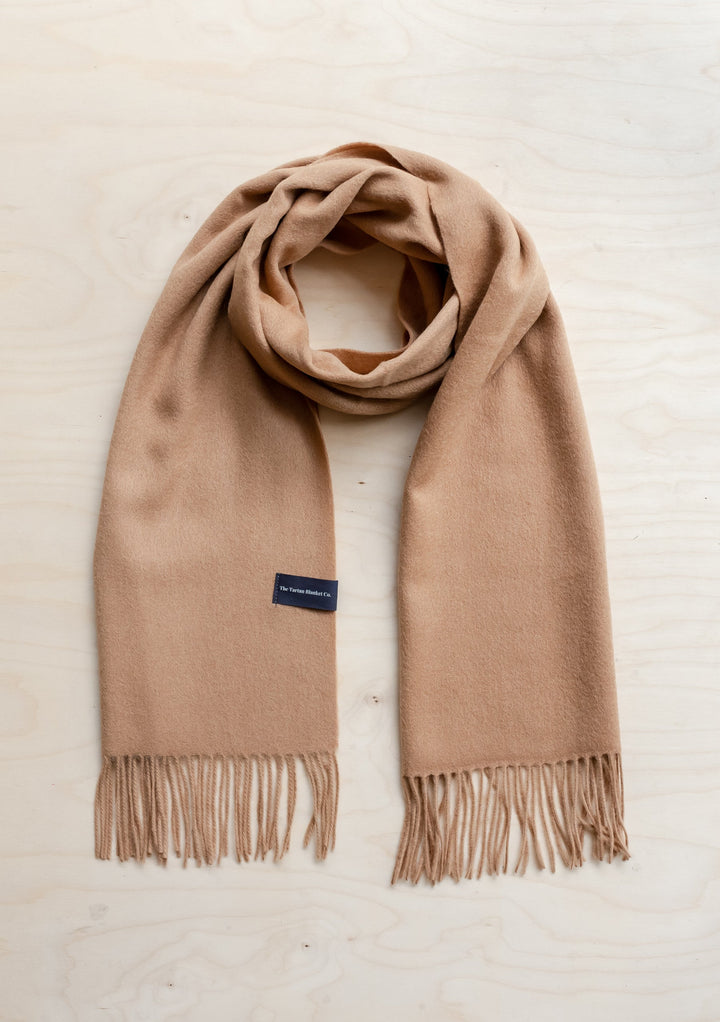 Luxurious TBCo men's cashmere scarf in camel colour with fringed ends, elegantly draped to showcase its soft texture