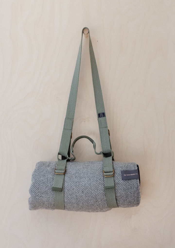 TBCo Recycled Picnic Carrier with sage green shoulder strap and brass buckles, featuring herringbone wool blanket roll