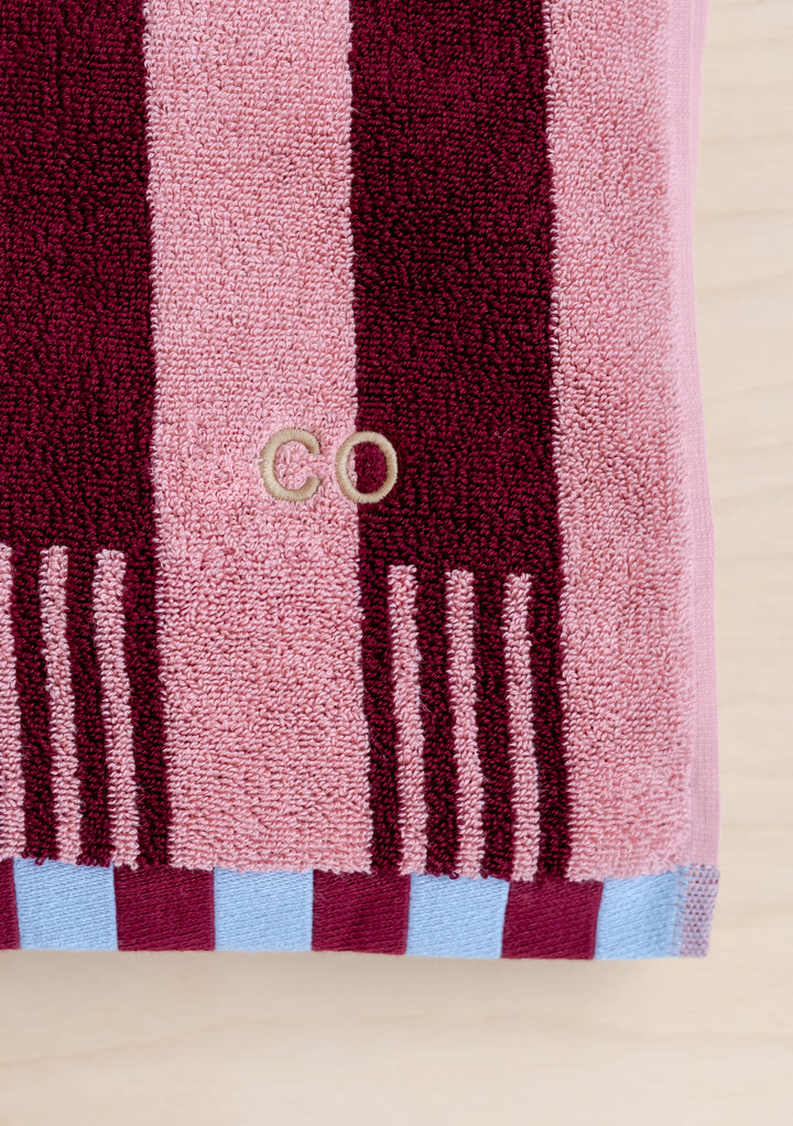 TBCo Cotton Towels in Pink Stripe with burgundy vertical stripes and blue checkered border, featuring embroidered logo detail