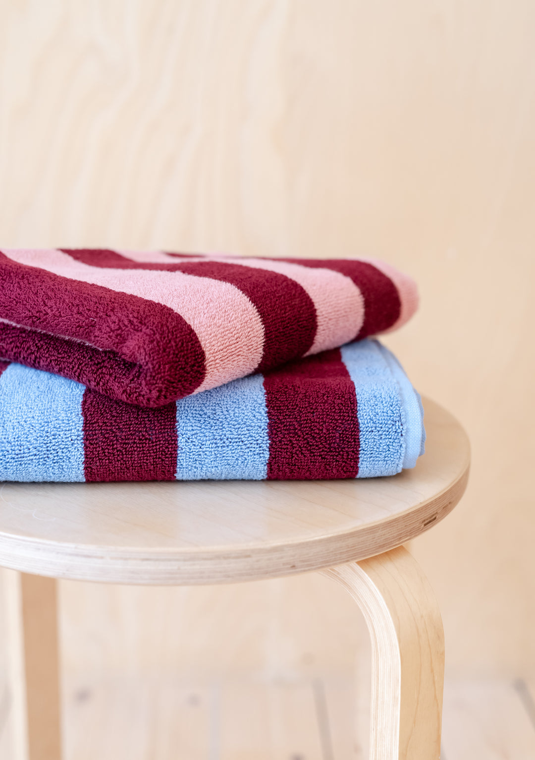 TBCo Mix & Match Towels Set featuring striped pink and blue cotton towels folded neatly on wooden stool