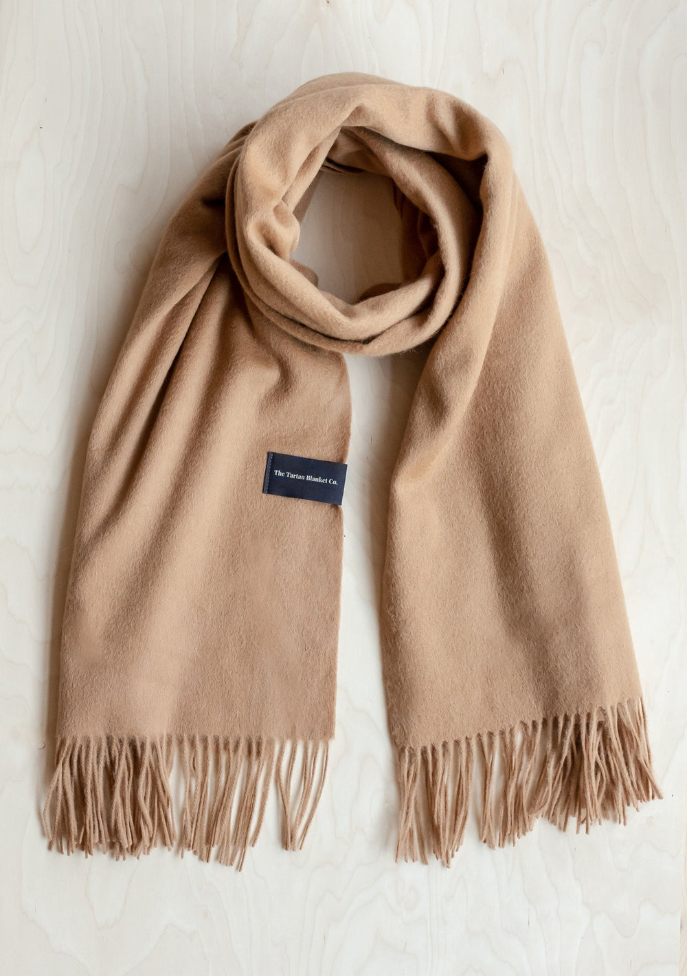 TBCo Lambswool Blanket Scarf in Camel displayed flat with fringed ends, showing soft texture and luxurious drape