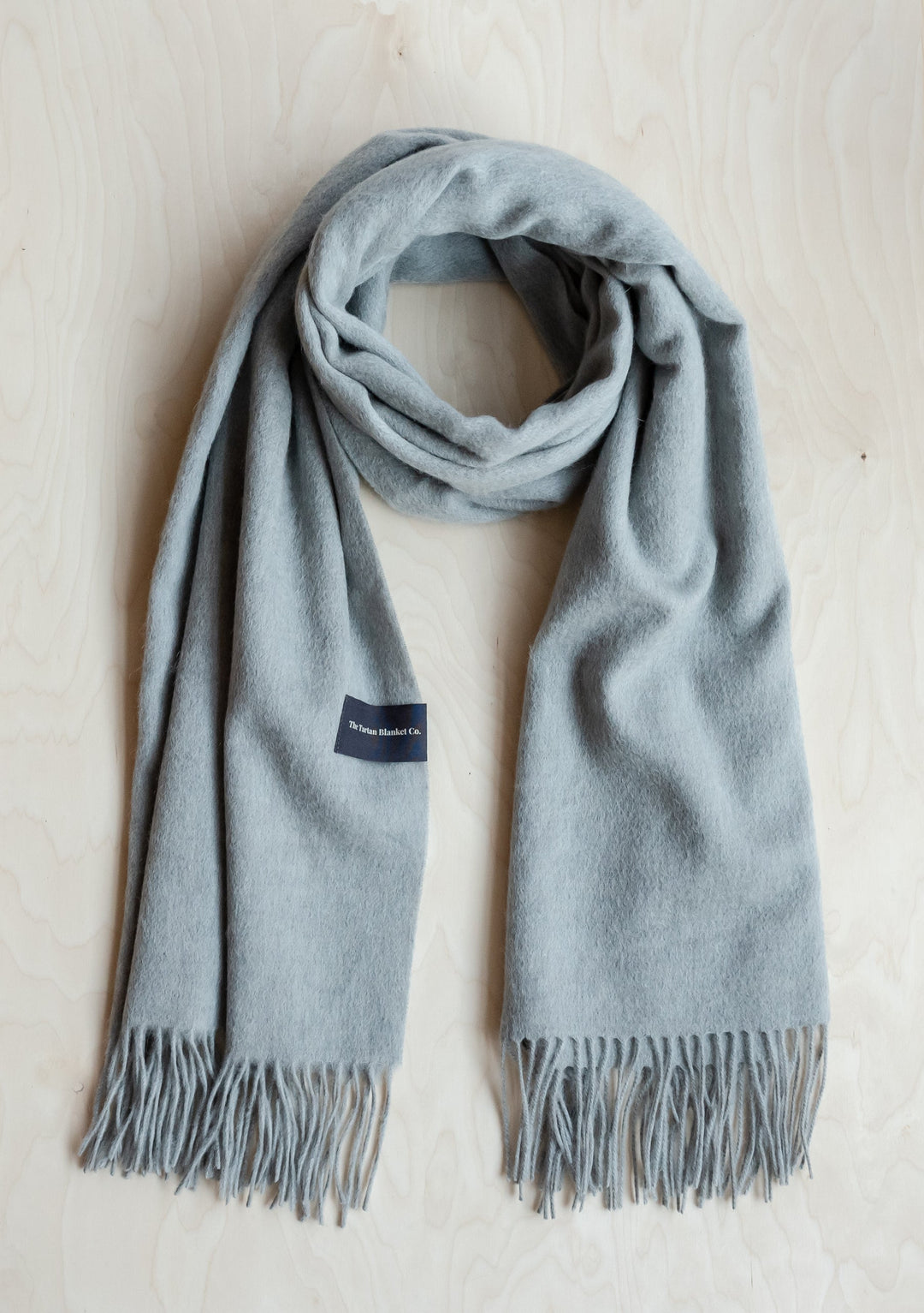 TBCo Lambswool Blanket Scarf in Light Grey Melange elegantly draped to showcase soft texture and fringed ends
