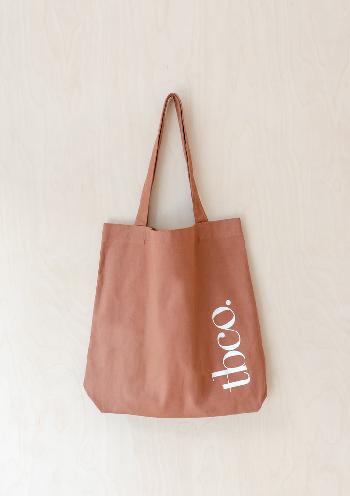 TBCo Recycled Cotton Tote in rust colour with long shoulder straps and white logo, made from durable canvas material