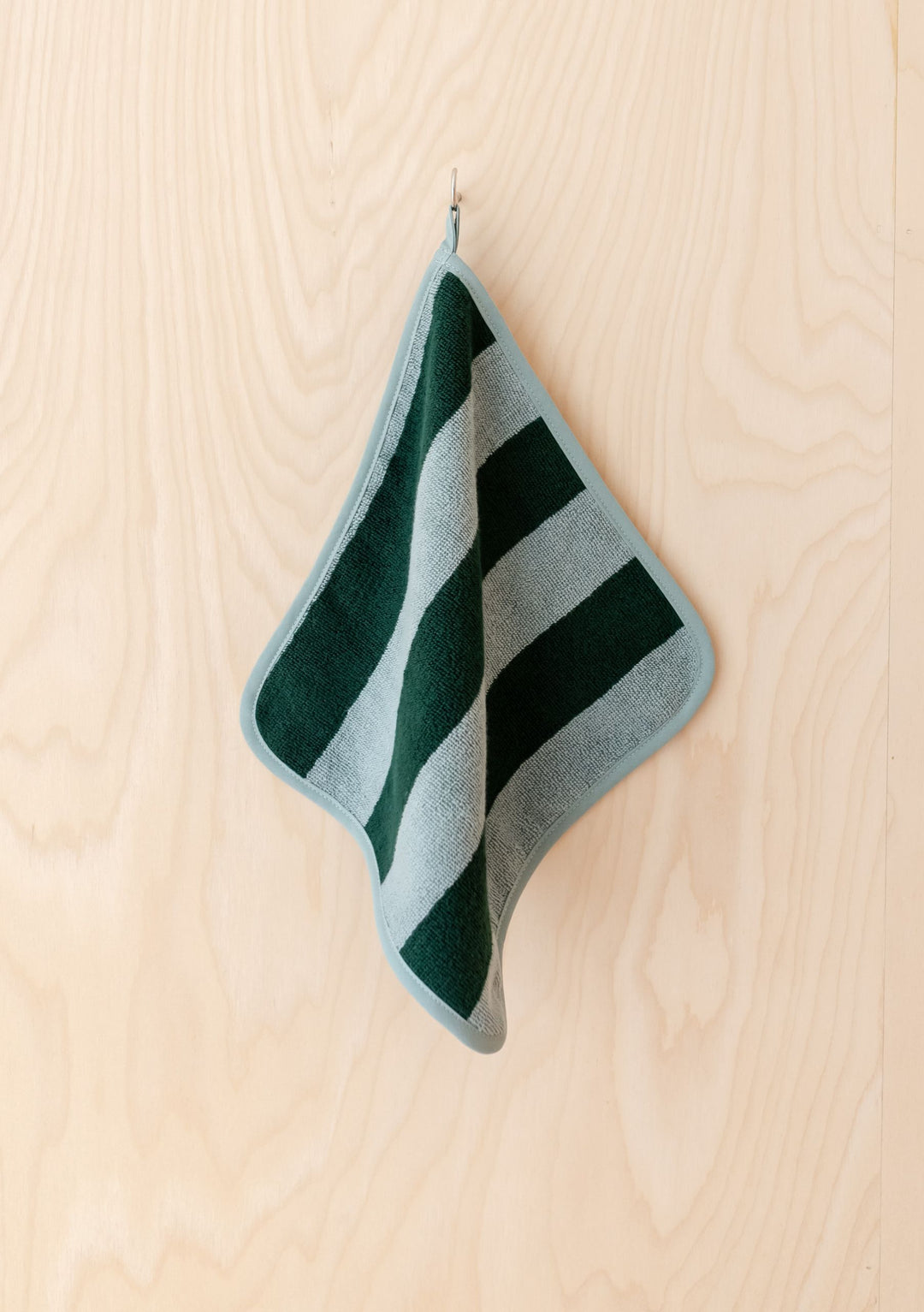 TBCo Terry Cotton Face Cloths Set of 2 in Green Stripe hanging on hook against light wooden background
