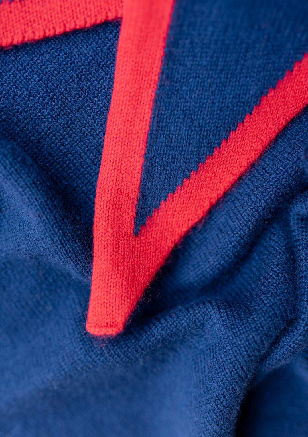 Close-up of the TBCo Merino Triangle Scarf in Navy & Red showing soft merino wool texture and red edging detail