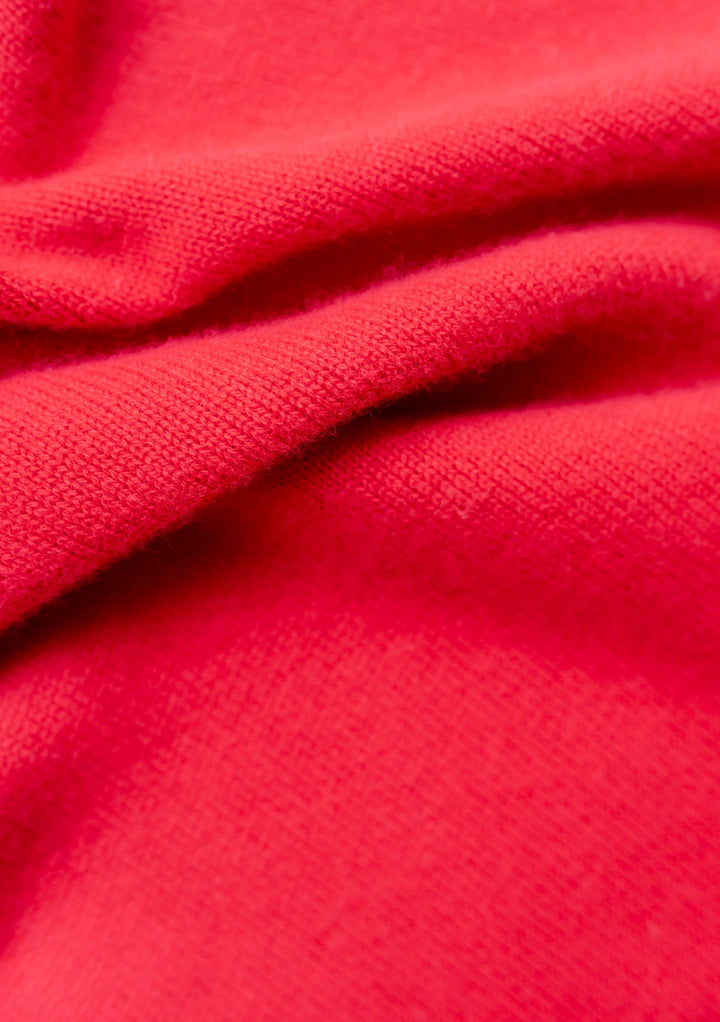 Close-up texture detail of TBCo Merino Triangle Scarf in vibrant red, showing soft knitted wool fabric with gentle folds