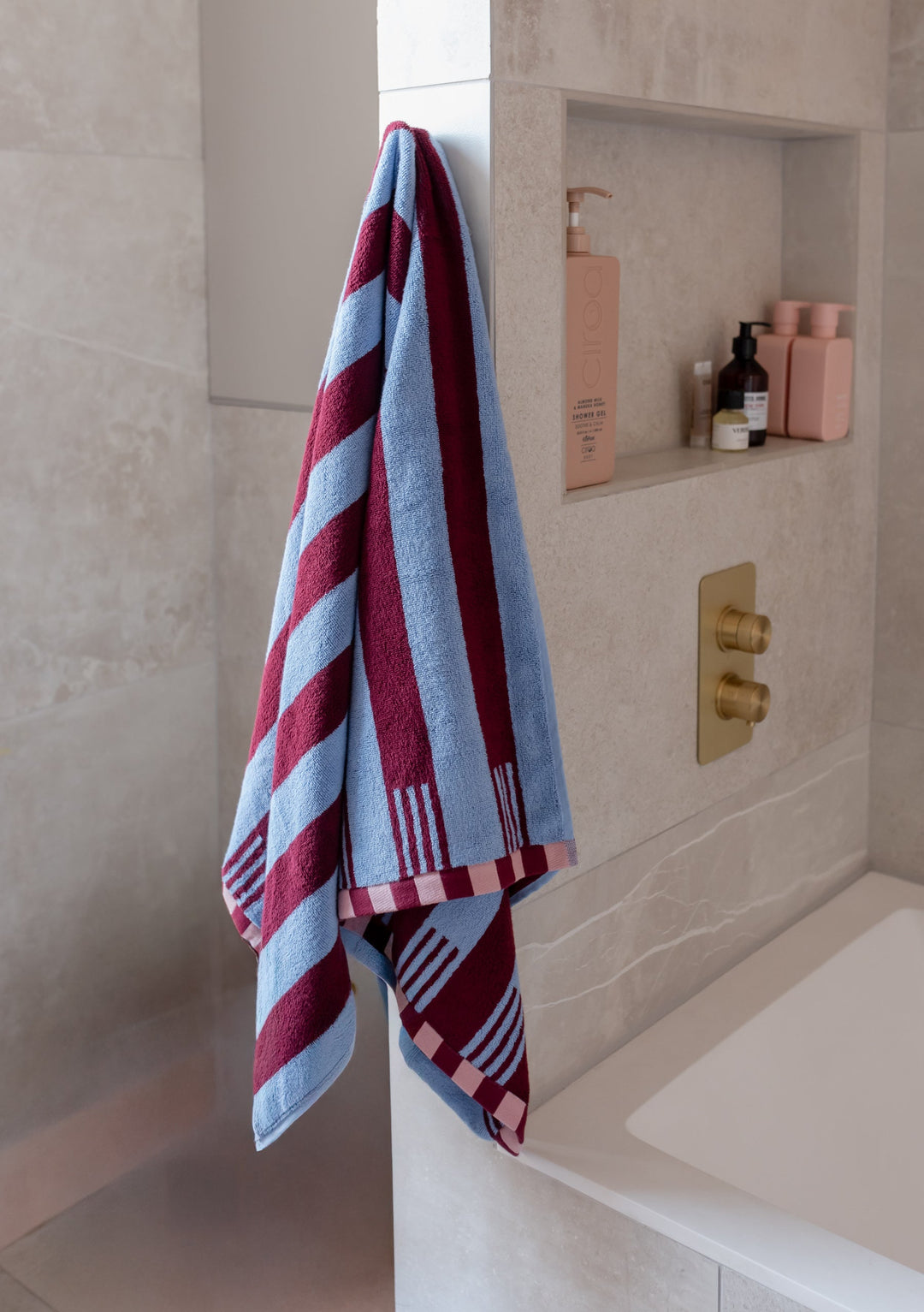 Luxurious TBCo Cotton Towels in Blue Stripe with burgundy stripes and checkered pattern hanging in modern bathroom