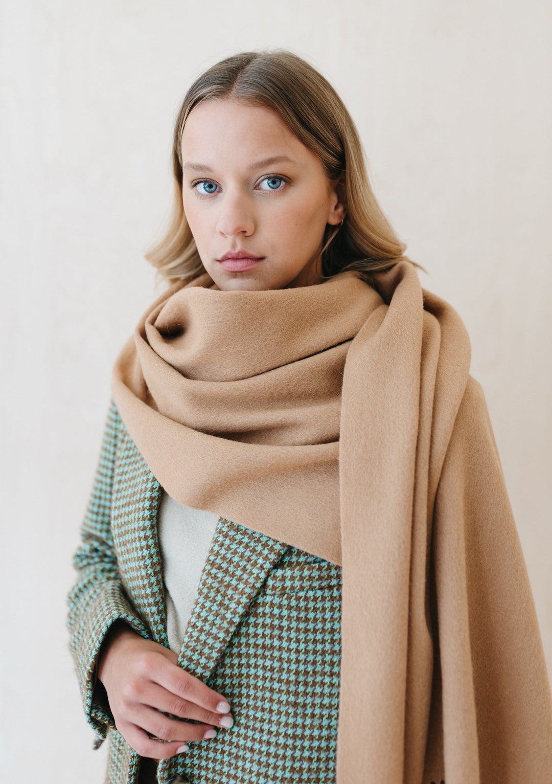 Luxurious TBCo camel cashmere blanket scarf draped elegantly with houndstooth jacket, showcasing soft texture and generous size