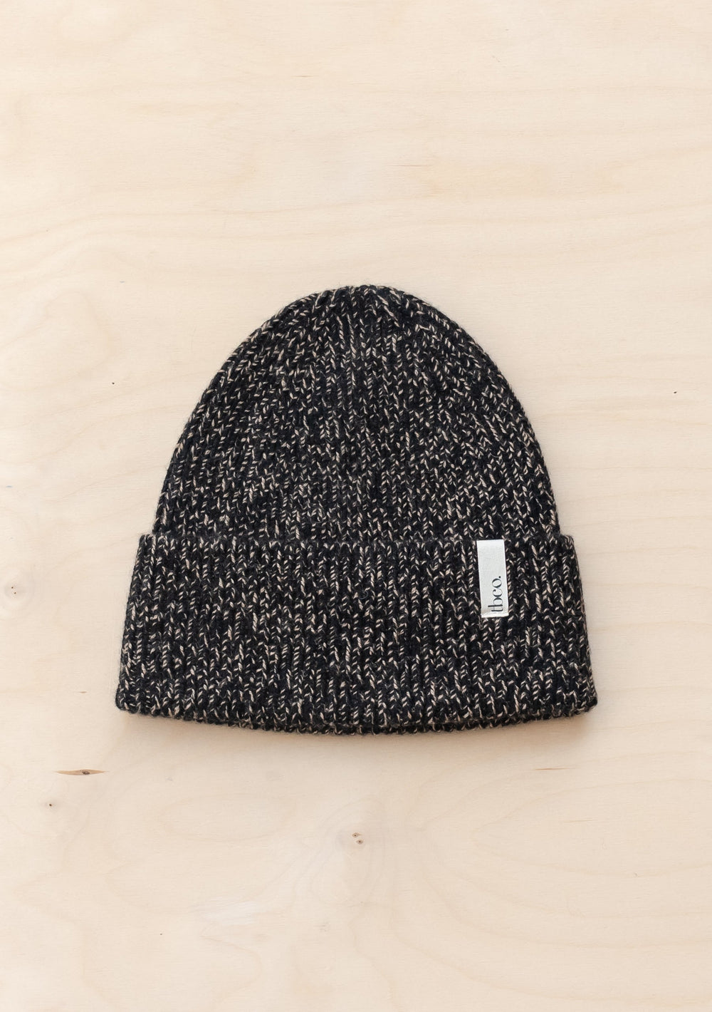 TBCo Cashmere & Merino Beanie in Black Fleck with twisted yarn pattern and ribbed cuff, featuring brand label