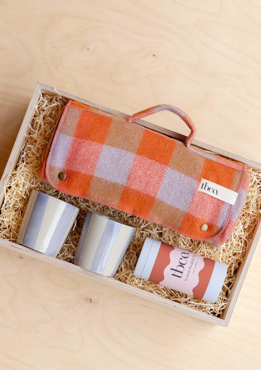 TBCo Picnic Gift Box featuring orange plaid blanket, ceramic cups and straw bedding in wooden presentation case