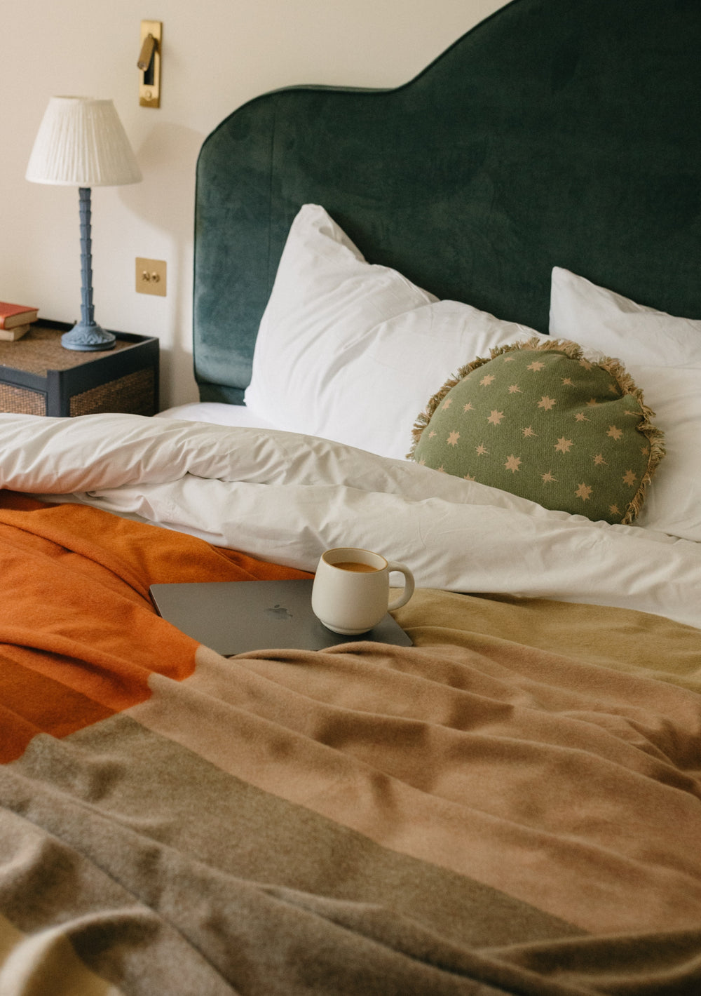 TBCo Cotton Cushion Cover in Sage Celestial displayed on white bedding with green velvet headboard and orange throw blanket