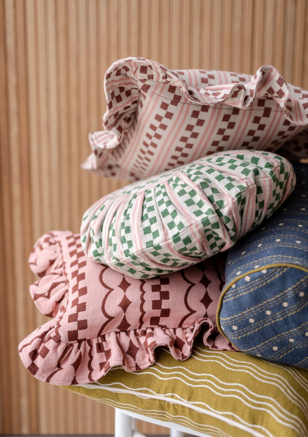 TBCo Cotton Bolster Cushion Cover in Navy Ditsy Floral pattern, styled with complementary patterned cushions on beige background