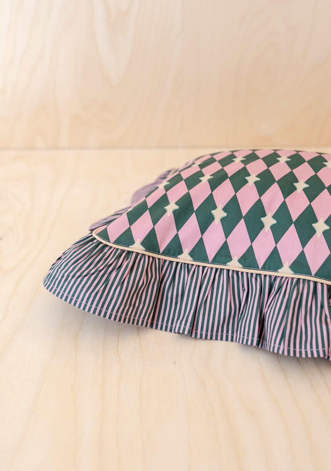 Cotton Cushion Cover in Pink Harlequin by TBCo with ruffled edge and reversible diamond and stripe pattern.