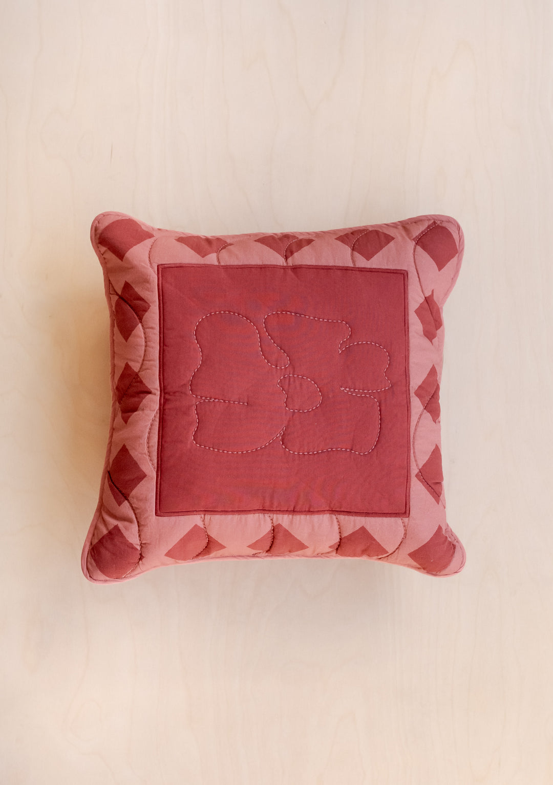 TBCo Flora Quilted Cushion Cover in red and pink cotton with floral pattern and geometric border stitching on cream background