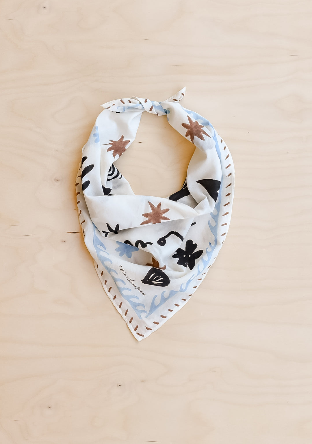TBCo Chiara Perano Artist Series Cotton Square Triangle Neck Scarf on a wooden background