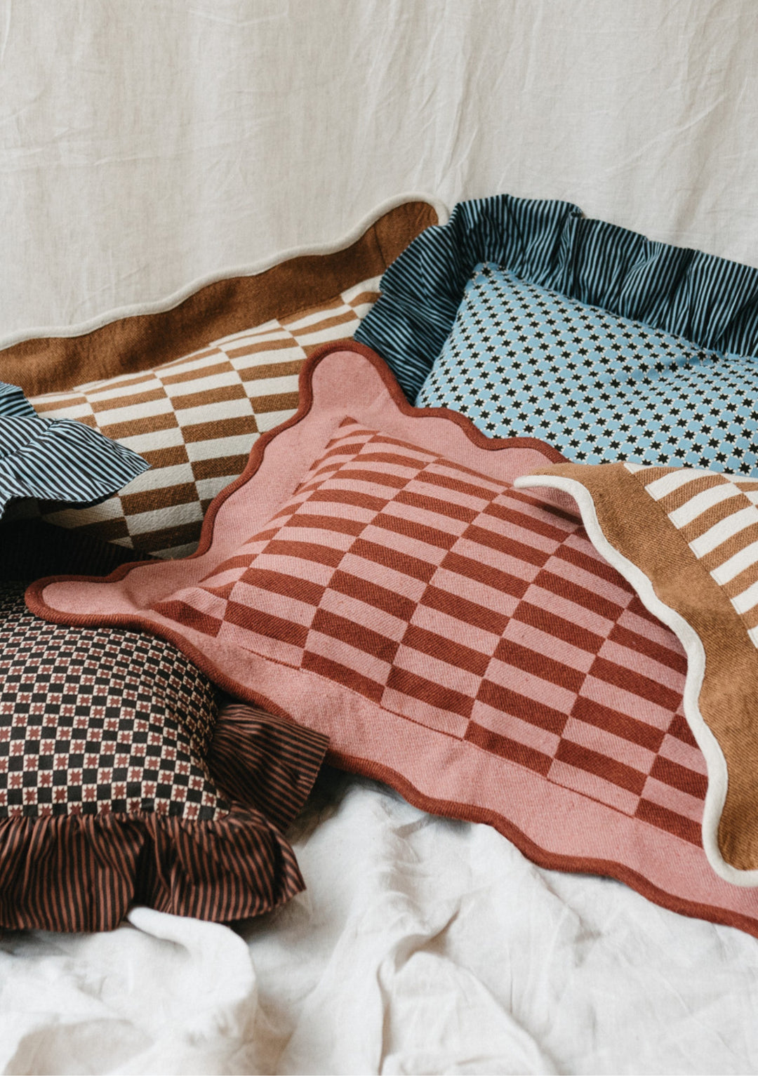 TBCo Mix & Match Cushion Set featuring geometric patterns in teal, pink and brown with frilled edges on sustainable cotton covers