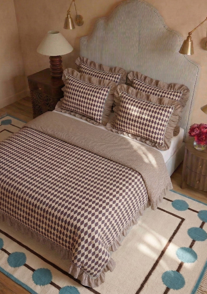 Bed with TBCo Cotton Duvet Cover & Pillowcases Set in Camel Harlequin featuring a harlequin print and ruffled edges in warm tones
