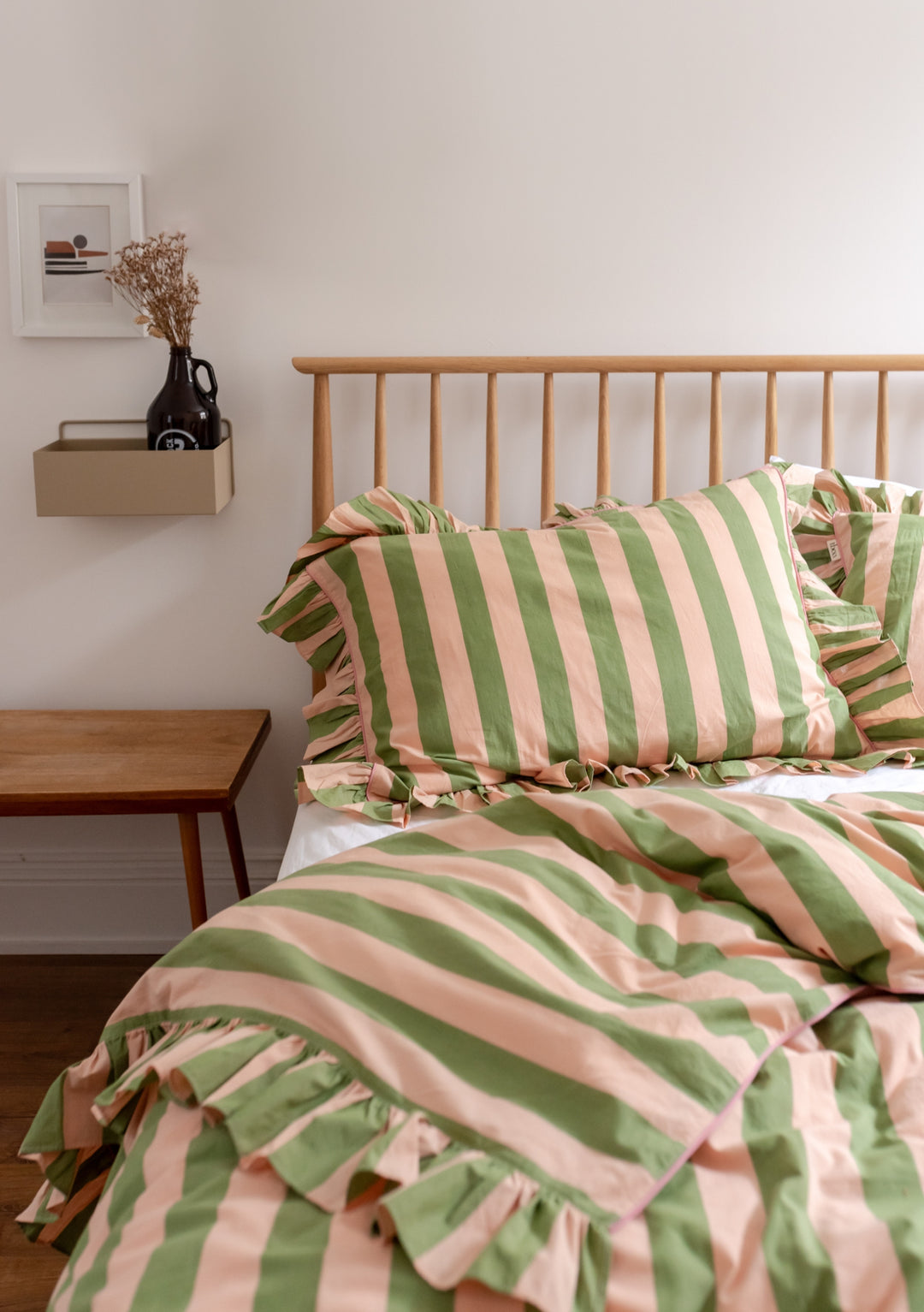 TBCo Cotton Duvet Cover in green and cream stripes with ruffled edges on wooden bed frame, styled with bedside table