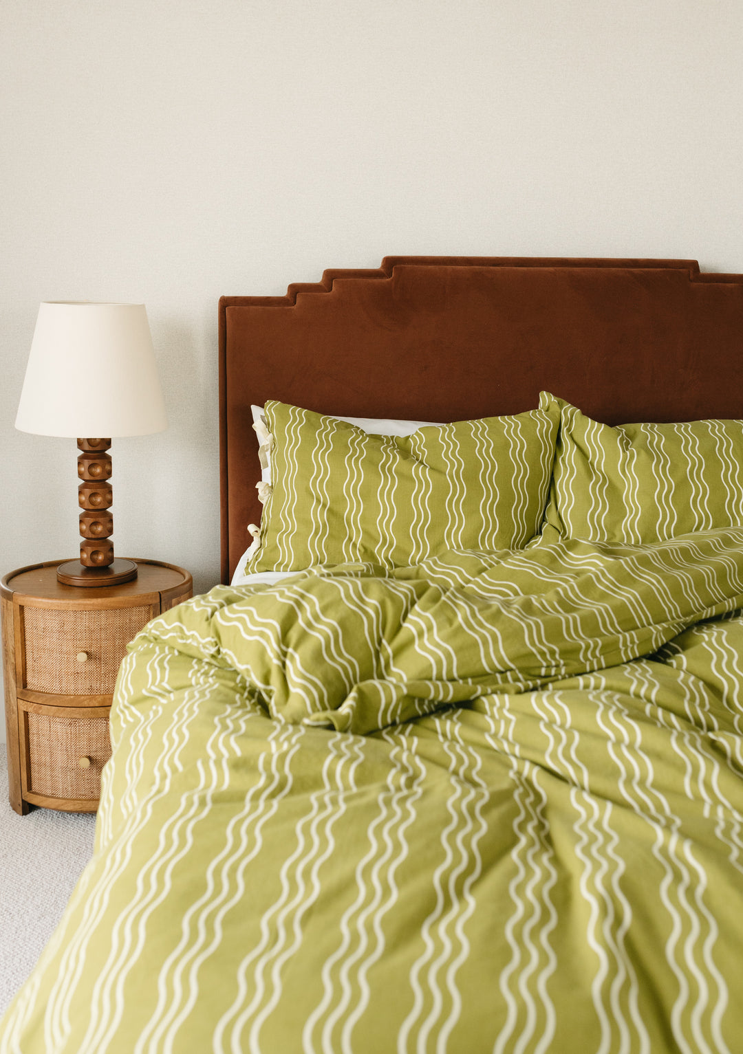 TBCo Cotton Duvet Cover in Olive Wave pattern displayed on bed with brown headboard and matching pillowcases