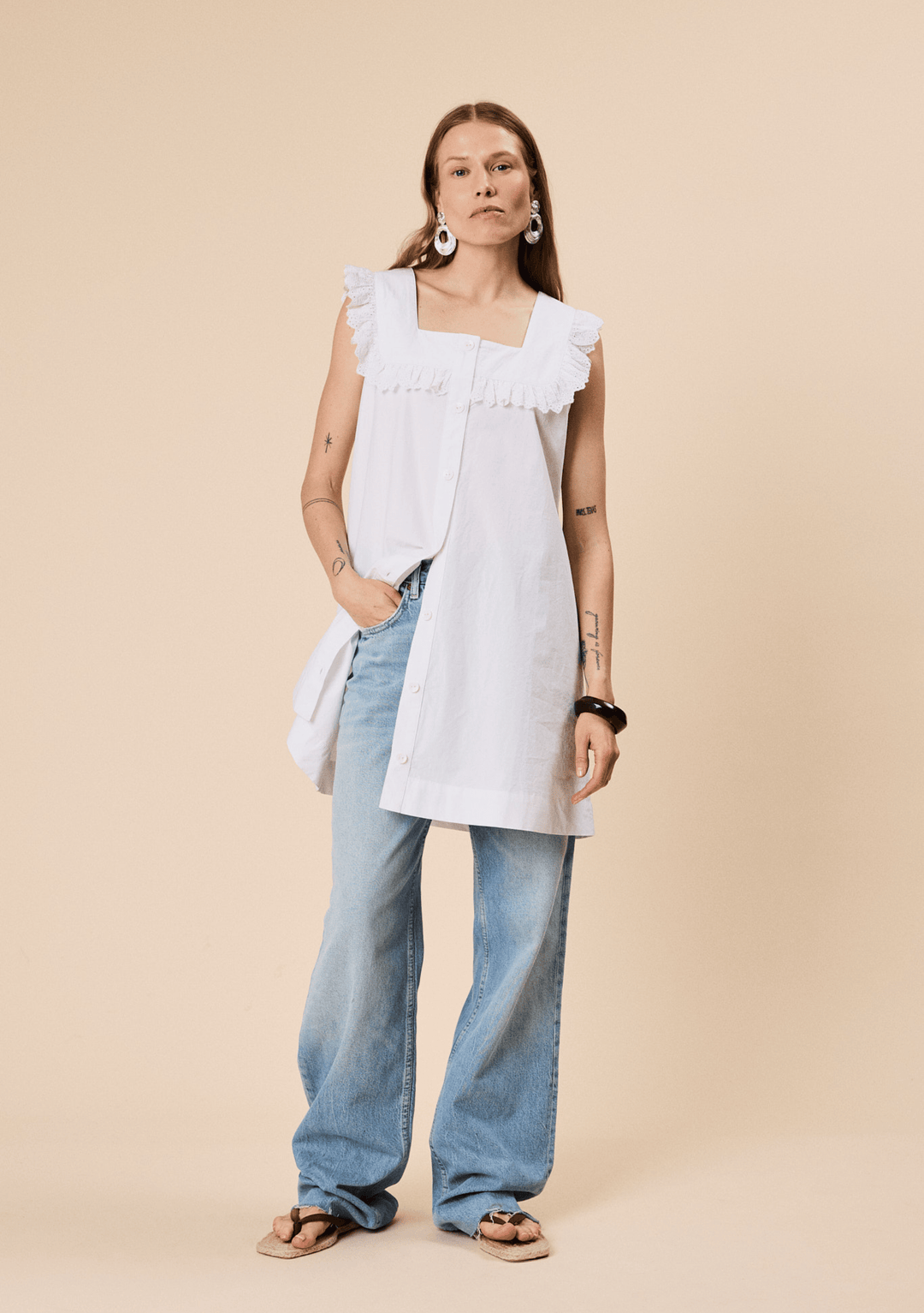 Woman wearing TBCo Cotton Broderie Sleeveless Dress in White made with natural and recycled fibres, women-founded, designed to make an impact