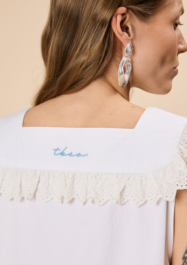 Close-up of the back of TBCo Cotton Broderie Sleeveless Dress in White, made with natural and recycled fibres, Designed to make an impact.
