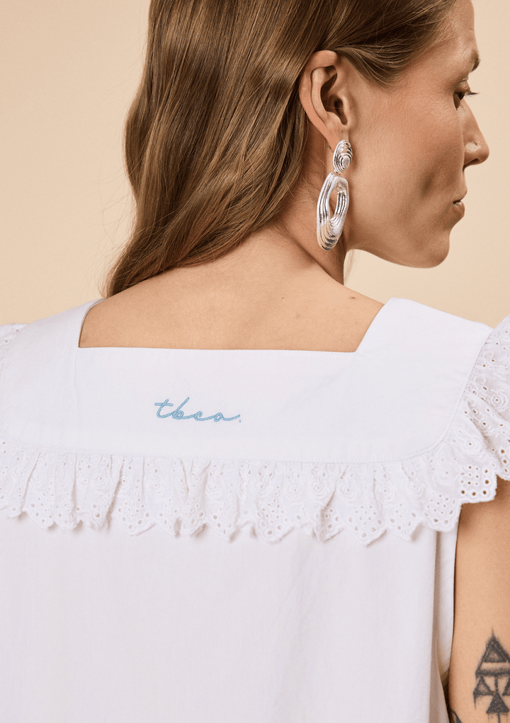 Close-up of the back of TBCo Cotton Broderie Sleeveless Dress in White, made with natural and recycled fibres, Designed to make an impact.
