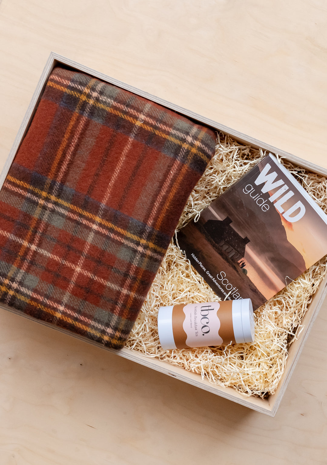 TBCo Ready-Made Scottish Gift Box featuring tartan blanket, tea tin and Wild Guide book nestled in straw-filled presentation box