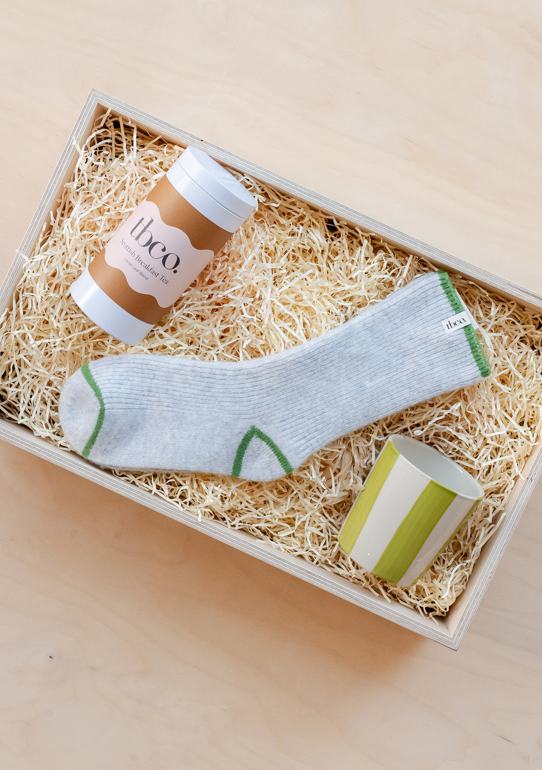 TBCo Ready-Made Cosy Gift Box featuring grey cashmere socks, green striped mug and Scottish breakfast tea in wood wool nest