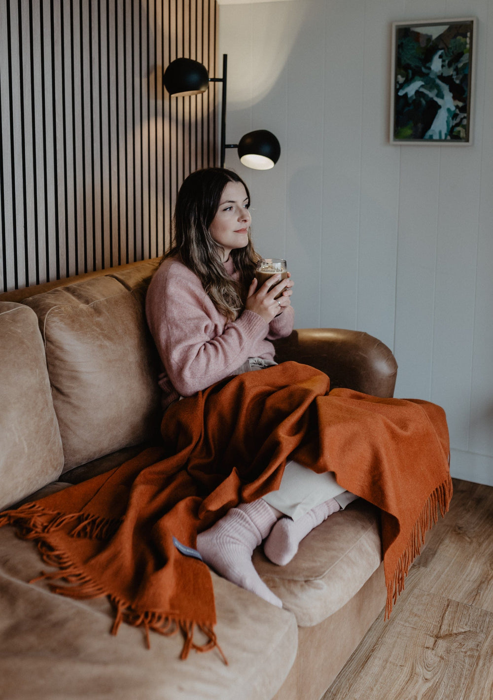 TBCo Lambswool Small Blanket in Rust Melange draped over couch with fringed edges, styled in cosy home setting