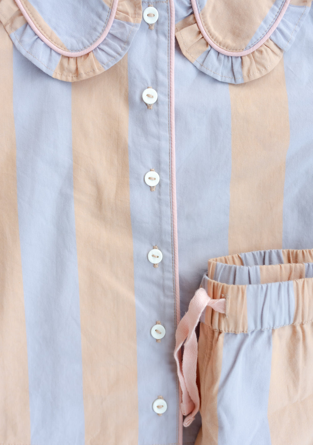 TBCo Cotton Kids Pyjamas featuring orange and lilac stripes with ruffled collar and button-down design, close-up detail
