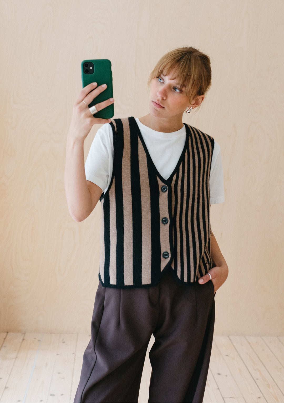 TBCo Merino Wool Vest in Latte Stripe shown styled with white t-shirt and dark trousers against neutral background