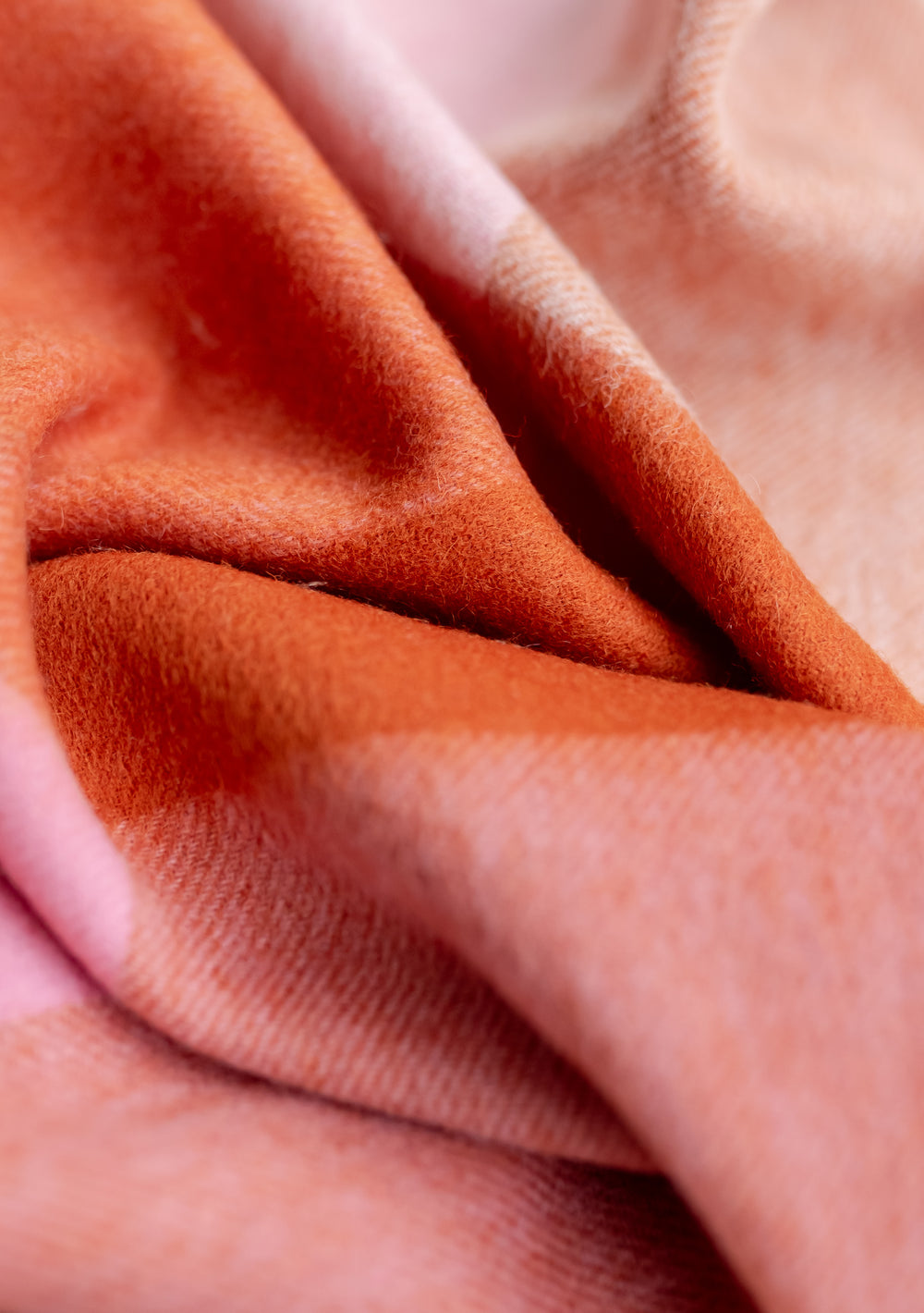 Close-up texture of TBCo Lambswool Kids Blanket in Blush Grid Check showing soft pink and rust wool weave pattern