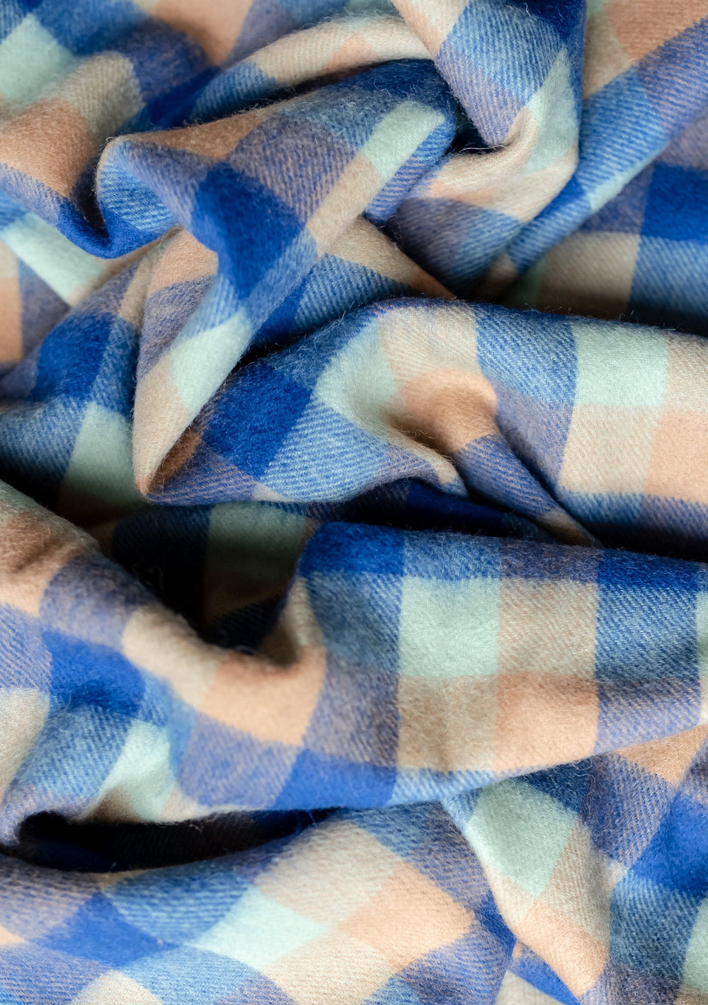 Close-up texture of TBCo Lambswool Kids Blanket in Blue Multi Gingham showing soft woven pattern in blue, green and camel checks