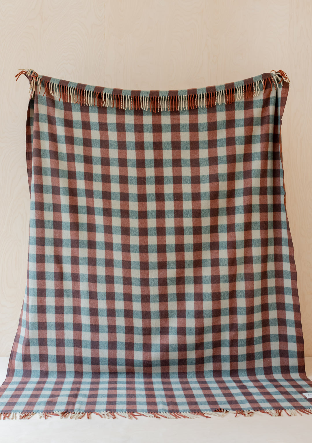 TBCo Recycled Wool Extra Large Blanket in teal and brown gingham pattern with fringed edges, displayed on beige backdrop