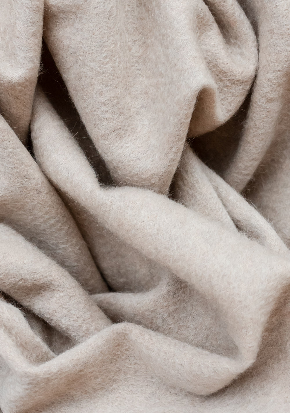 Luxurious TBCo Cashmere Small Blanket in Oatmeal Melange with soft folds and textured weave detail