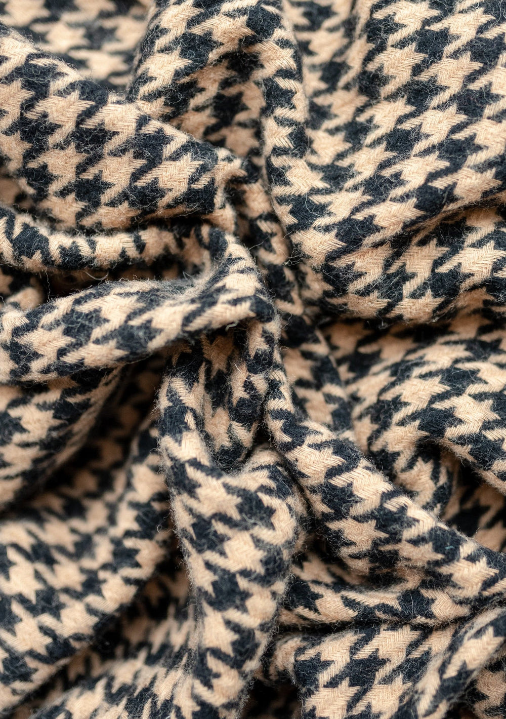 Close-up texture detail of TBCo Lambswool Blanket in Camel Houndstooth pattern showing soft woven wool fabric with classic design
