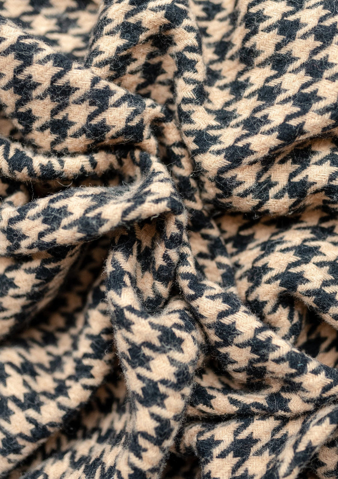 Close-up texture detail of TBCo Lambswool Blanket in Camel Houndstooth pattern showing soft woven wool fabric with classic design