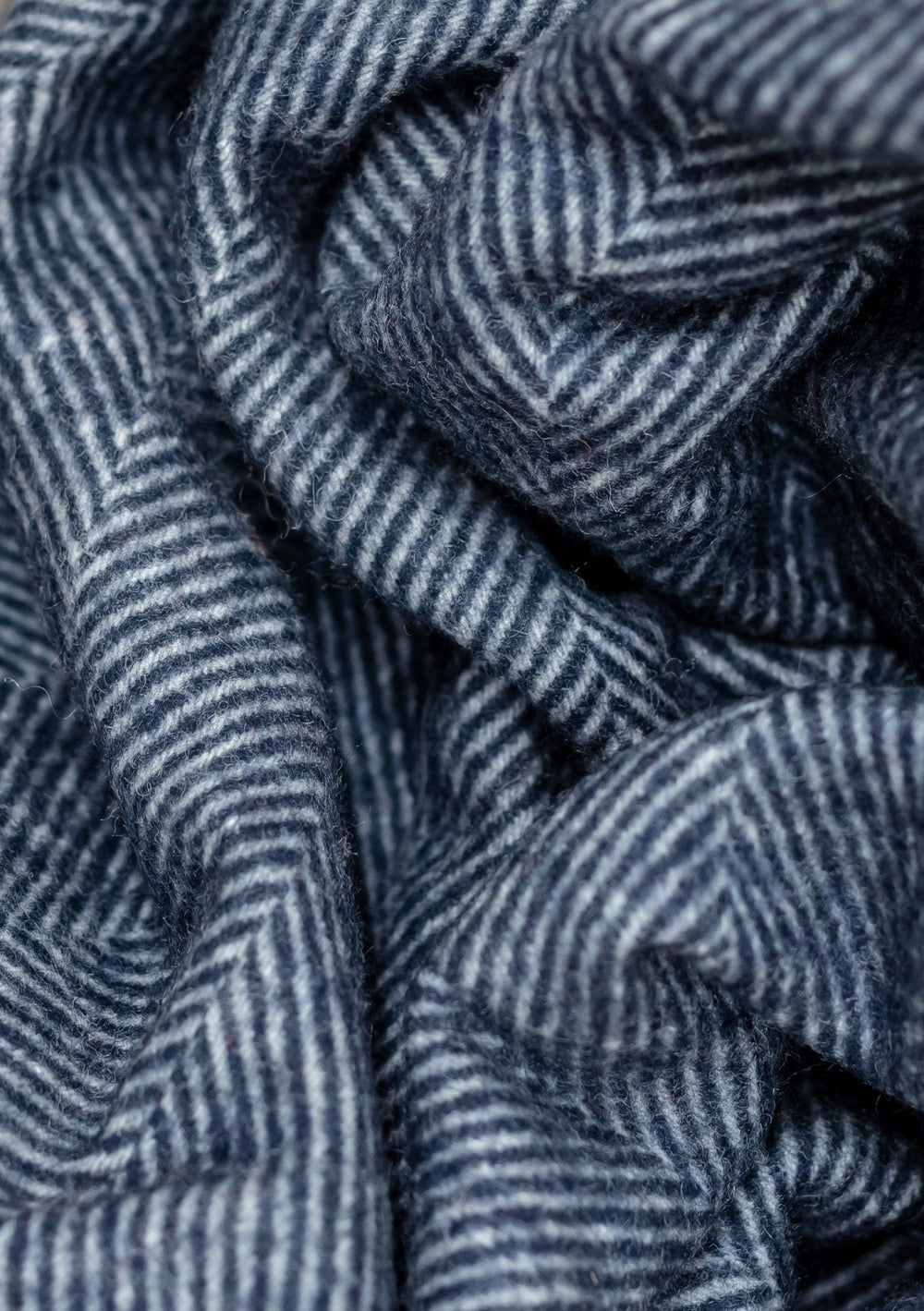 Close-up texture detail of TBCo Recycled Wool Small Blanket in Navy Herringbone pattern showing woven wool fibres