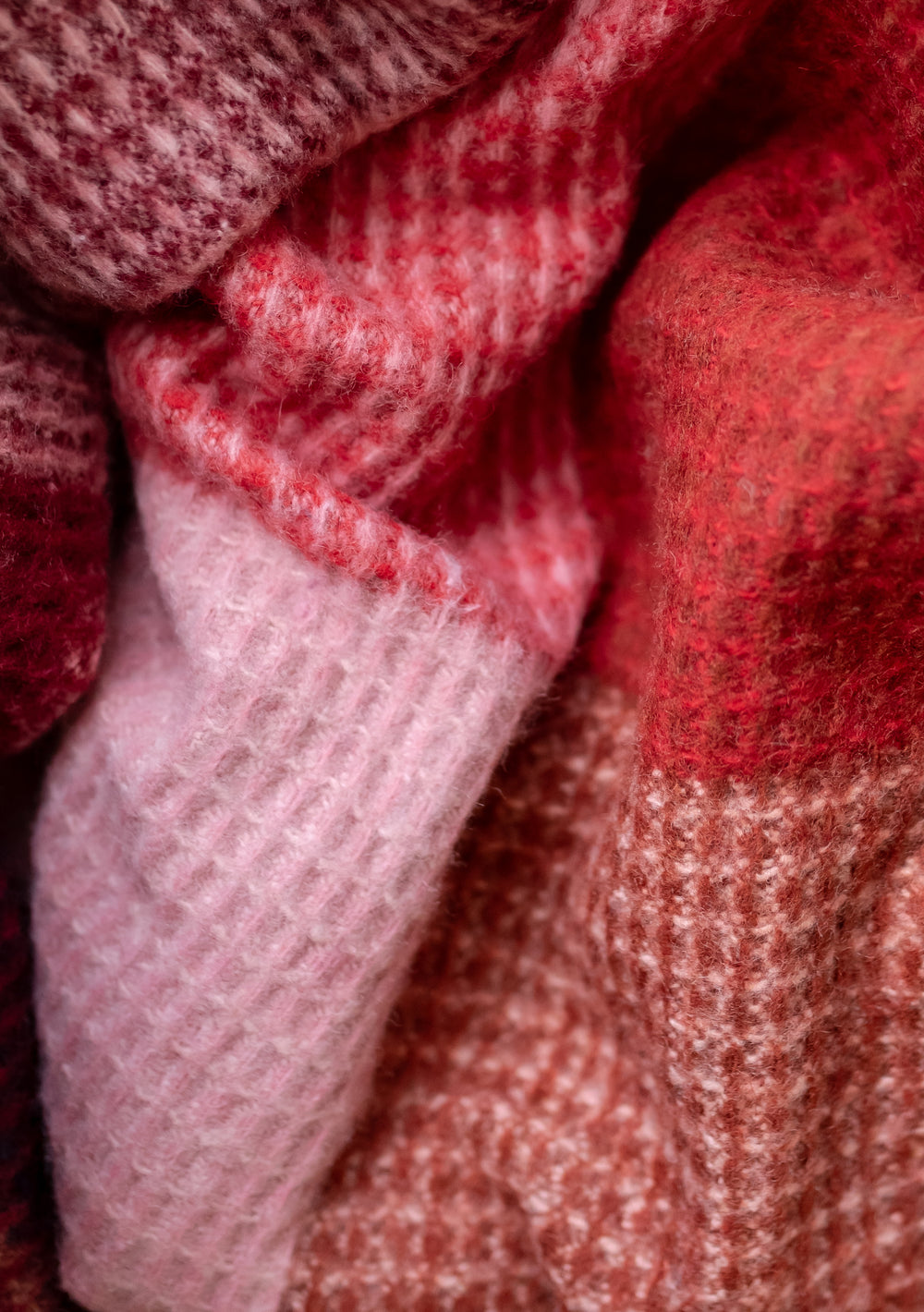 TBCo Recycled Wool Blanket in Berry Waffle Block Check pattern shown in close-up texture detail with pink and red tones