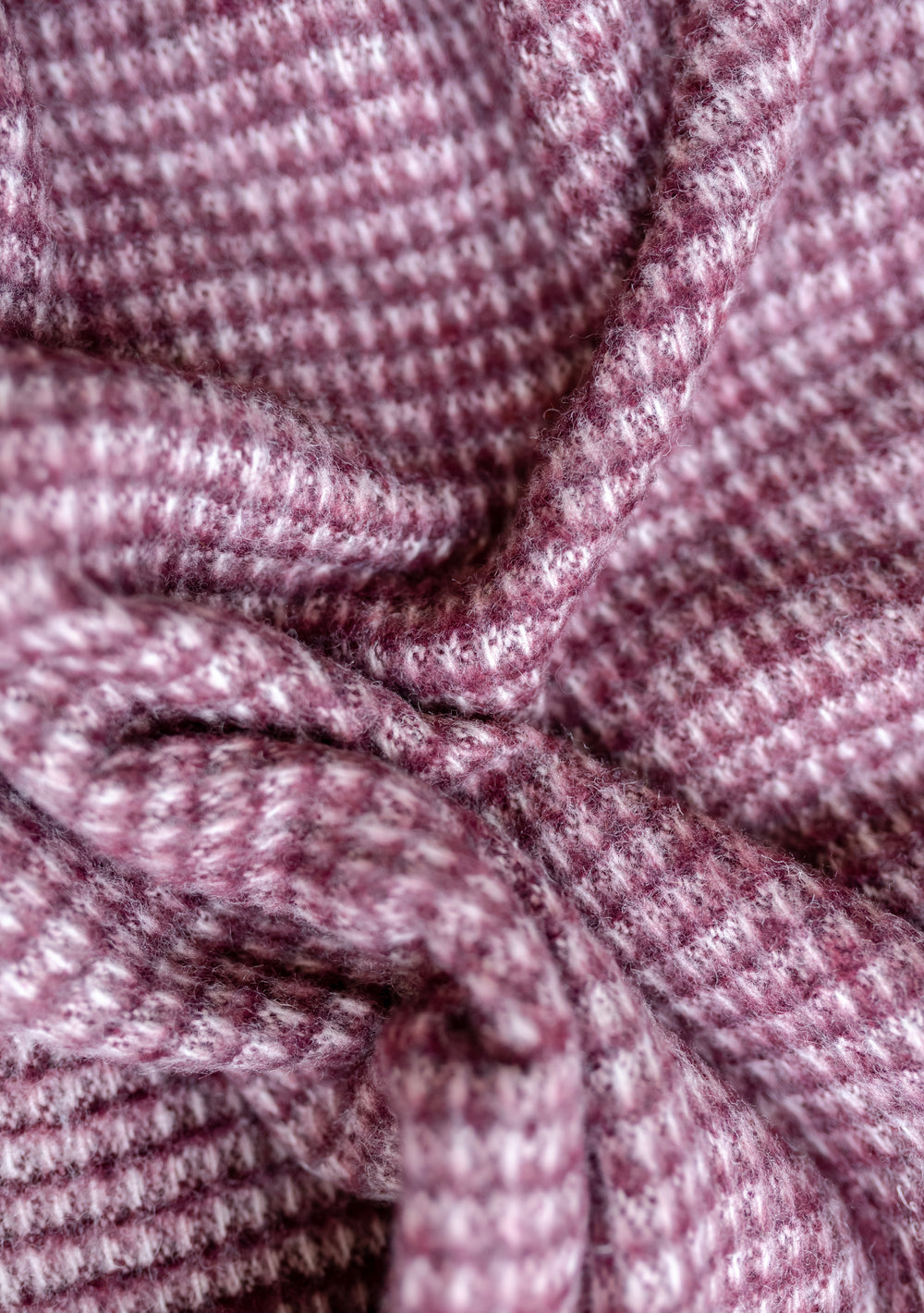 Close-up texture detail of TBCo Recycled Wool Blanket in Berry Waffle showing soft waffle-knit pattern in berry pink shade