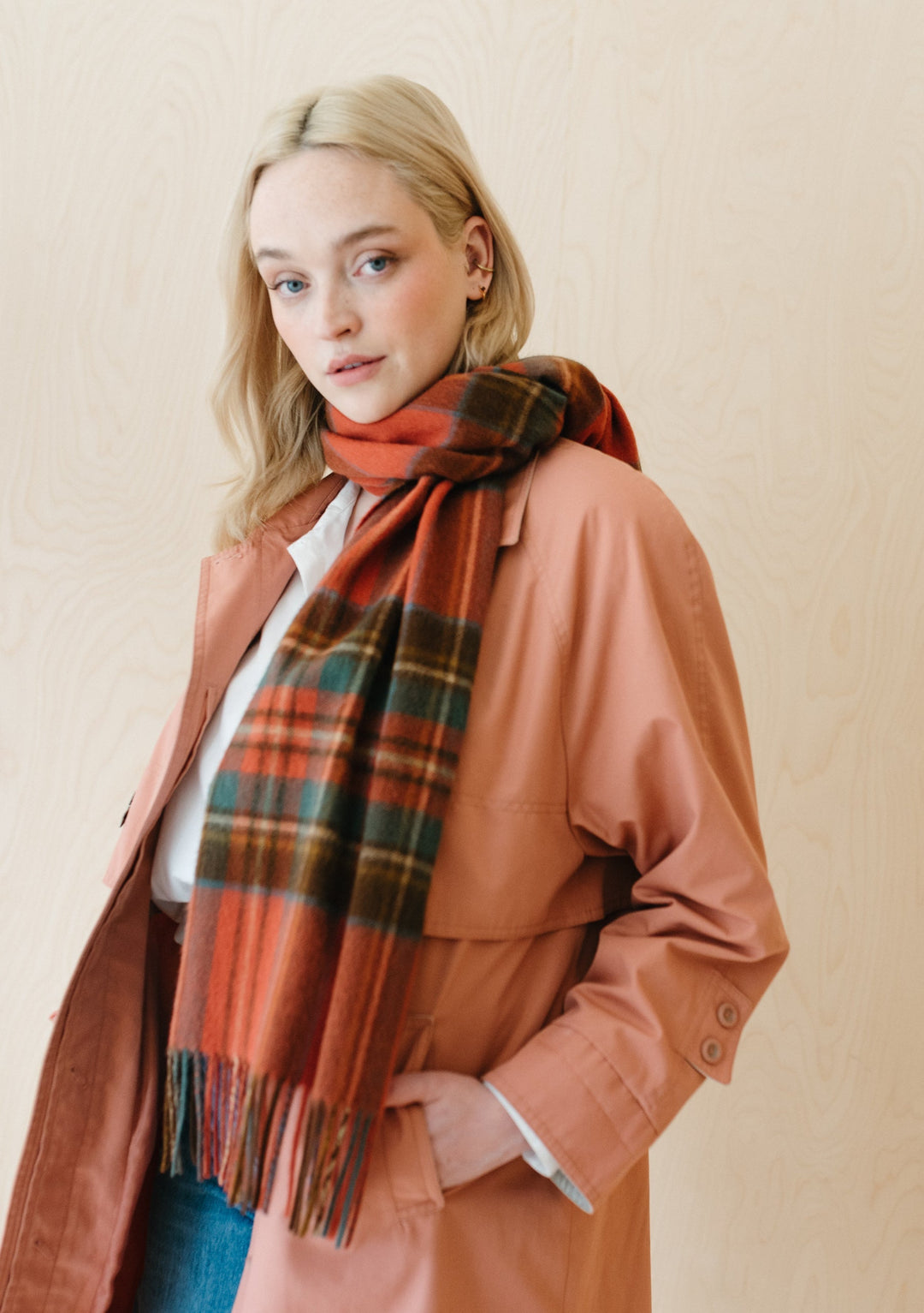 TBCo Lambswool Oversized Scarf in Stewart Royal Antique Tartan styled with peach coat showing plaid pattern and fringe detail