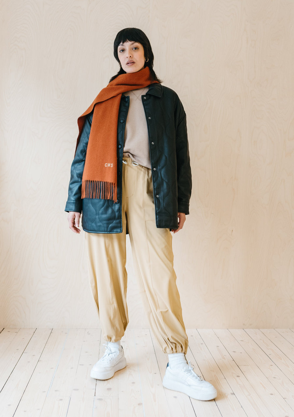 TBCo rust melange lambswool scarf styled with dark jacket and cream trousers, showcasing fringed detail and cosy winter wear