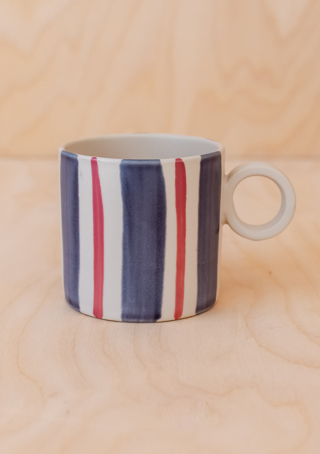 Blue Stripe Hand-Painted Mug by TBCo, ceramic mug with bold vertical blue and red stripes and round handle detail