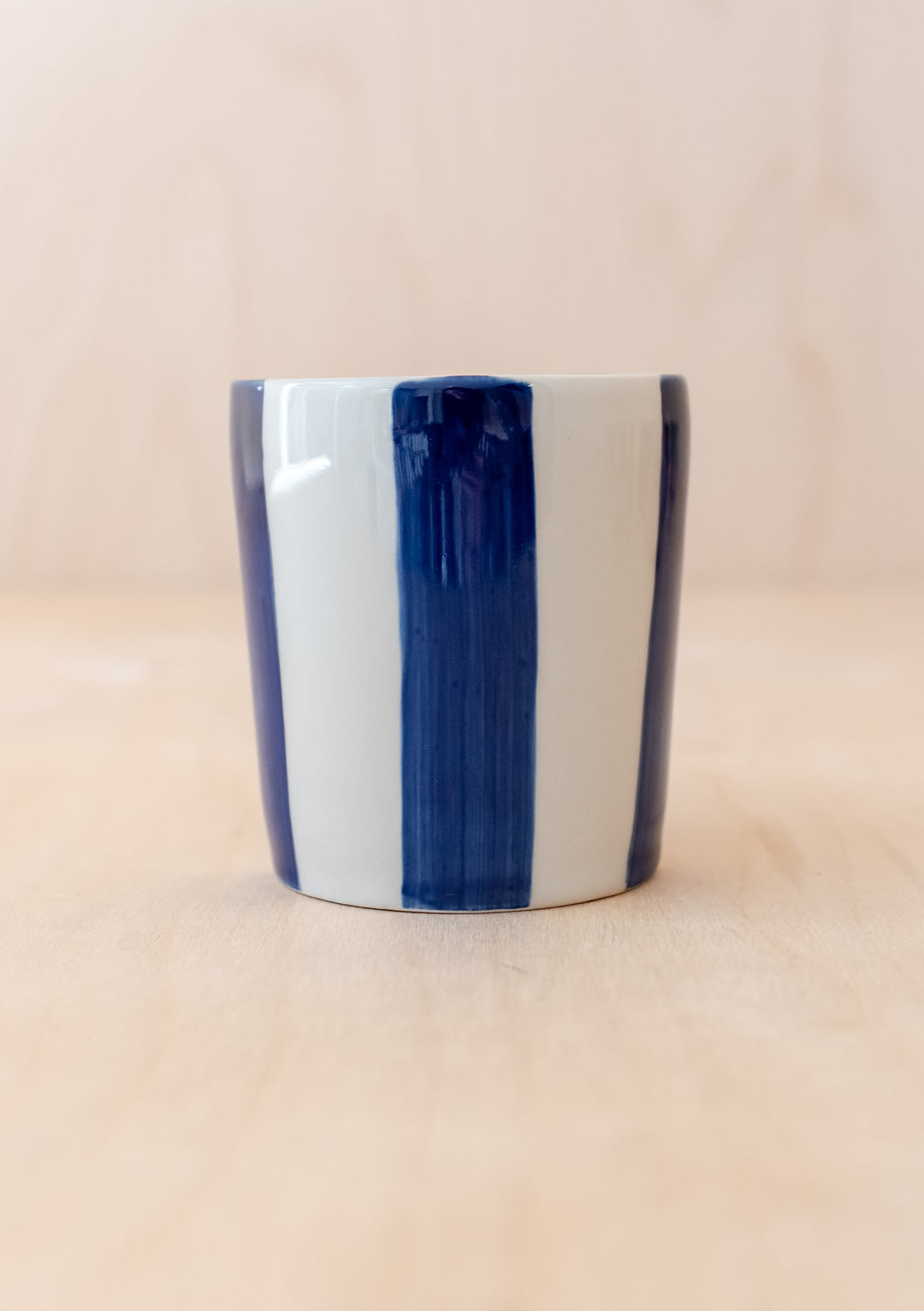 Handcrafted TBCo Navy Stripe Mug featuring vertical navy and white stripes on cylindrical ceramic handleless design