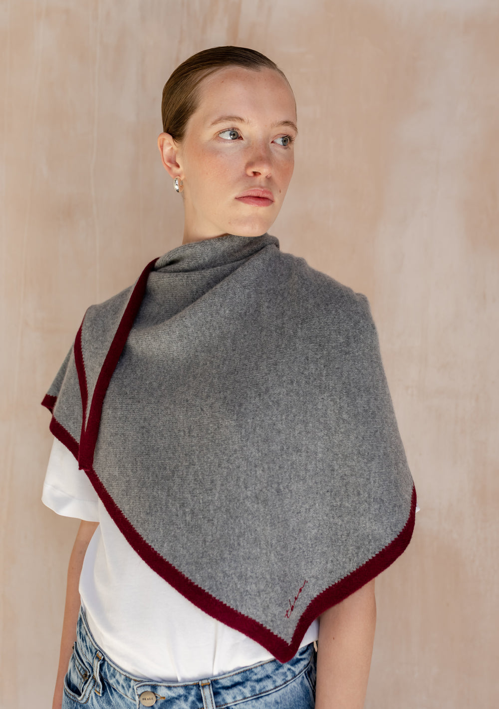 Model wearing TBCo Large Merino Wool Triangle Scarf in Charcoal & Burgundy over a white t-shirt and light-wash jeans, showcasing its versatile style and soft texture.